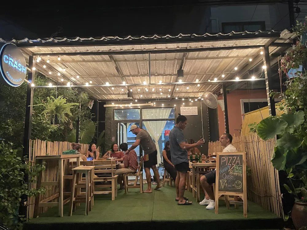 Crash front terrace at night with string lights and people eating